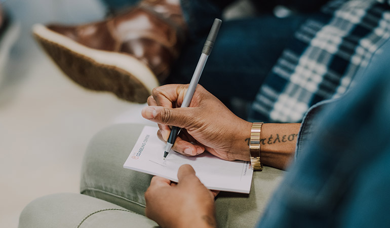 a man writing notes in a group session at Clark